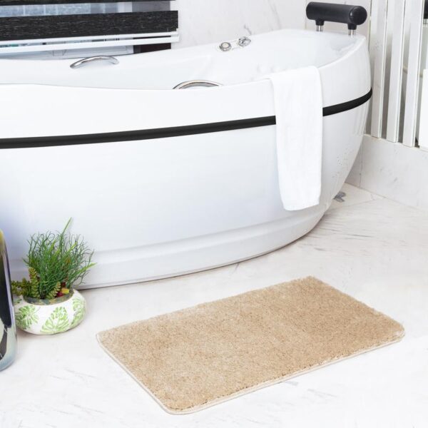 Baignoire moderne avec tapis de bain beige.