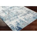 Tapis moderne bleu et blanc sur plancher bois.