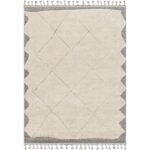 Tapis beige à motifs losanges et franges.