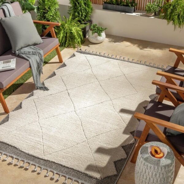 Terrasse moderne avec mobilier et tapis extérieur.