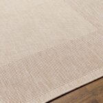 Tapis beige texturé sur plancher en bois.