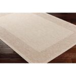 Tapis beige texturé sur plancher en bois.