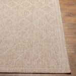 Tapis beige à motifs géométriques sur plancher en bois.