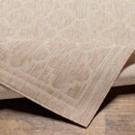 Tapis beige texturé sur plancher en bois.