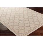 Tapis beige à motifs géométriques sur parquet.