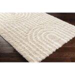 Tapis beige texturé sur parquet brun.