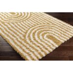 Tapis beige à motifs concentriques sur plancher bois.