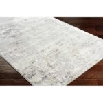 Tapis moderne gris sur parquet brun.