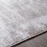 Tapis gris texturé sur plancher en bois