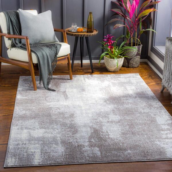 Salon moderne avec tapis gris et fauteuil.