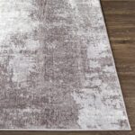 Tapis gris texturé sur plancher en bois.