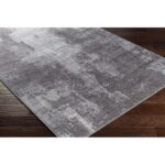 Tapis gris moderne sur plancher de bois.