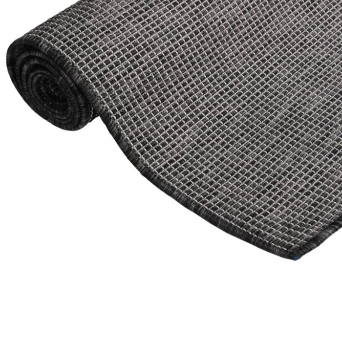 Tapis noir roulé texture grillagée.