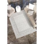 Tapis géométrique salon, fauteuils crème, décoration intérieure moderne.