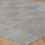 Tapis gris à motif géométrique en relief.