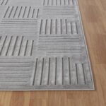 Tapis gris moderne sur plancher en bois.