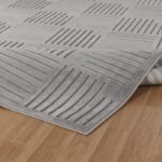 Tapis texturé gris sur plancher en bois.