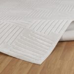 Tapis blanc texturé sur sol en bois