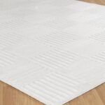 Tapis blanc texturé sur plancher en bois.