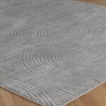 Tapis gris texturé sur plancher en bois.