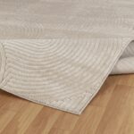 Tapis beige texturé sur plancher bois.