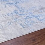 Tapis bleu et gris sur plancher en bois.
