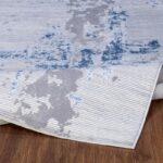 Tapis moderne gris et bleu sur plancher en bois.
