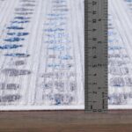Tapis avec motif bleu mesuré par règle.