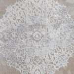 Tapis motif dentelle gris et beige.