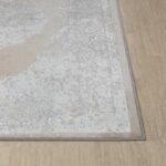 Tapis beige à motifs sur plancher en bois.
