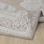Tapis beige à motifs floraux sur sol en bois.