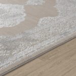 Tapis beige à motifs dentelle sur sol en bois.