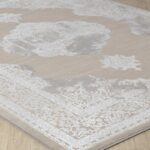 Tapis décoratif gris et blanc, motifs floraux.