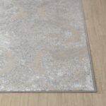 Tapis gris avec motifs élégants sur sol en bois.