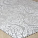 Tapis gris à motifs baroques sur sol en bois