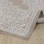 Tapis beige à motifs floraux sur plancher bois.