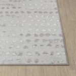 Tapis gris et blanc motif abstrait.