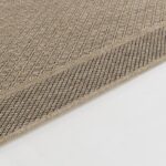 Tapis texturé en jute beige sur fond blanc.