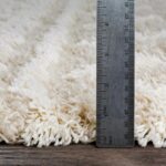 Règle métallique mesurant tapis moelleux.