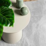 Table moderne avec bougie et feuille verte.