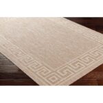 Tapis beige à motif géométrique sur plancher bois.