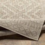 Tapis beige avec motif géométrique sur parquet