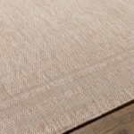 Tapis beige texturé sur sol en bois.