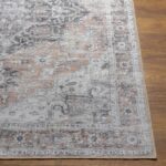 Tapis classique gris et beige sur parquet.