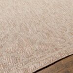 Tapis en fibres naturelles sur plancher en bois.