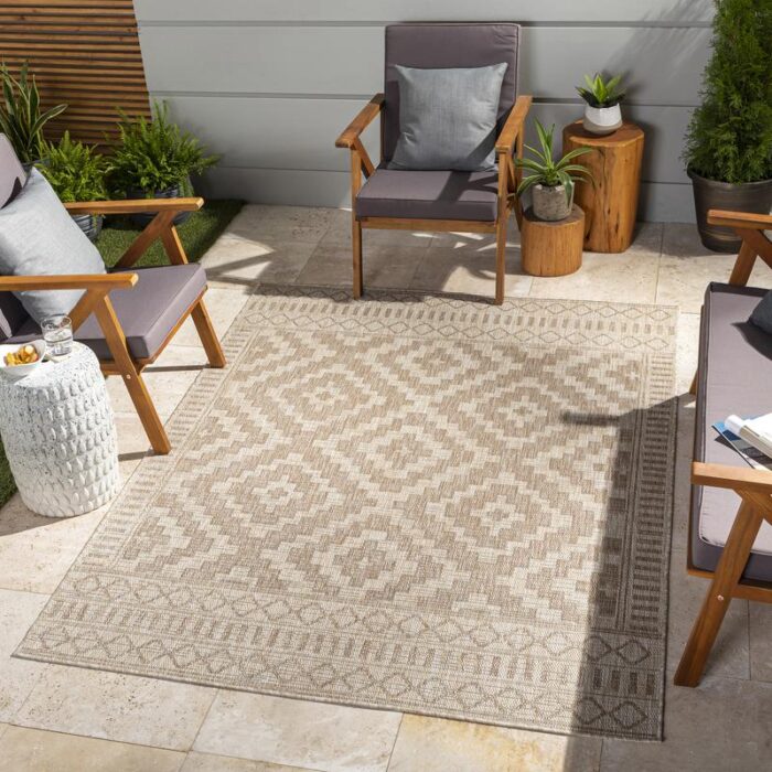 Tapis extérieur motif géométrique avec mobilier de jardin.