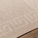 Tapis texturé beige sur parquet en bois.