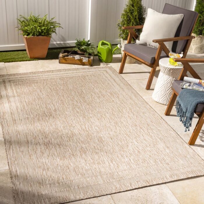 Terrasse moderne avec tapis d'extérieur et mobilier en bois.